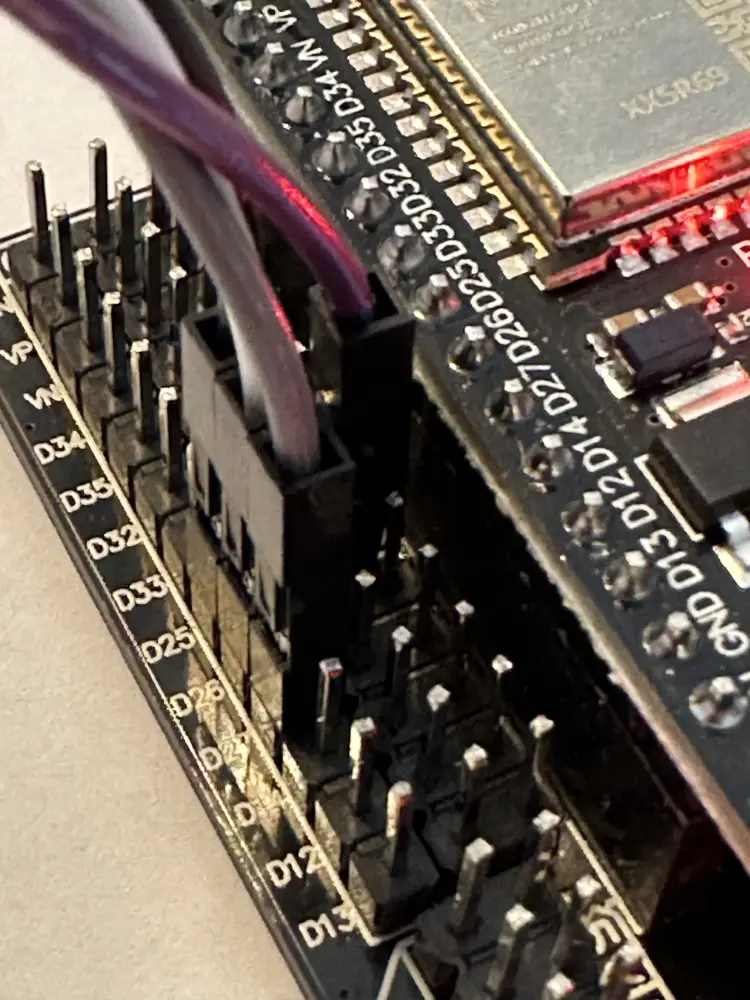 Makroaufnahme der Pinreihen auf dem schwarzen Expansion Board mit eingesteckten weiblichen Jumper-Kabeln an den GPIOs