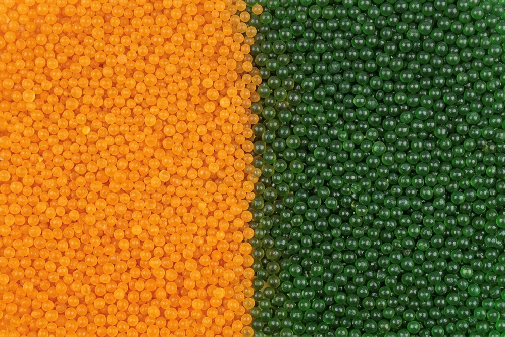 „Vergleich von orangem (trockenem) und grünem (gesättigtem) Silica-Gel Granulat.